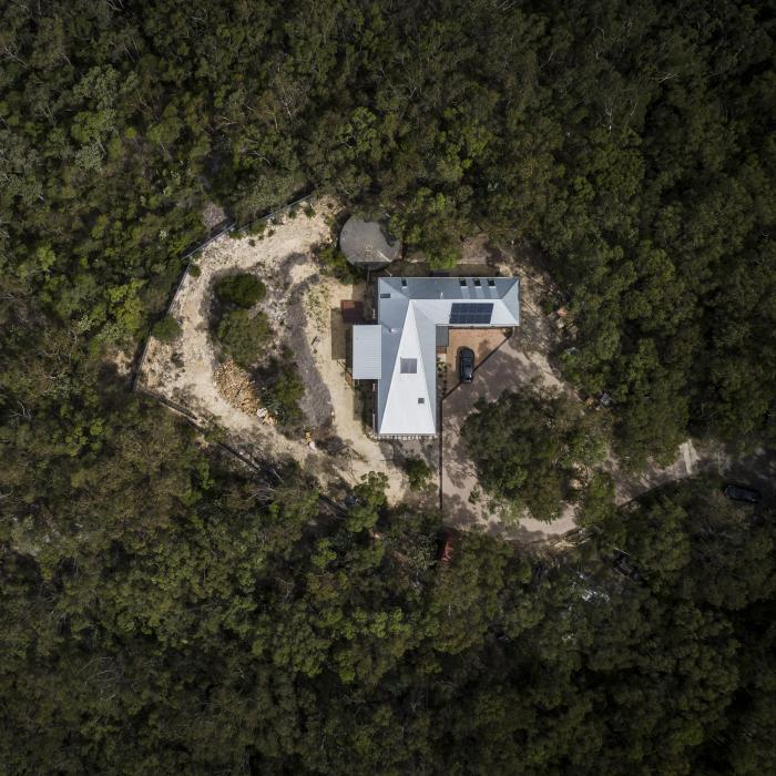 A photo of a home with a LYSAGHT® steel roof, surrounded by bushland