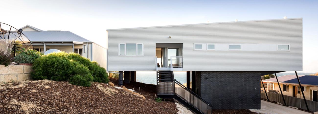 Contemporary stilted home with COLORBOND® Surfmist® walling, designed for coastal conditions and modern aesthetics.